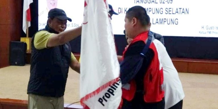 Penyerahan bendera PMI Kalsel oleh Gubernur Kalsel H Sahbirin Noor atau Paman Birin kepada Ketua Kontingen Sandi Fitrian Noor yang juga putra Paman Birin. (foto : istimewa/Adpim Kalsel)