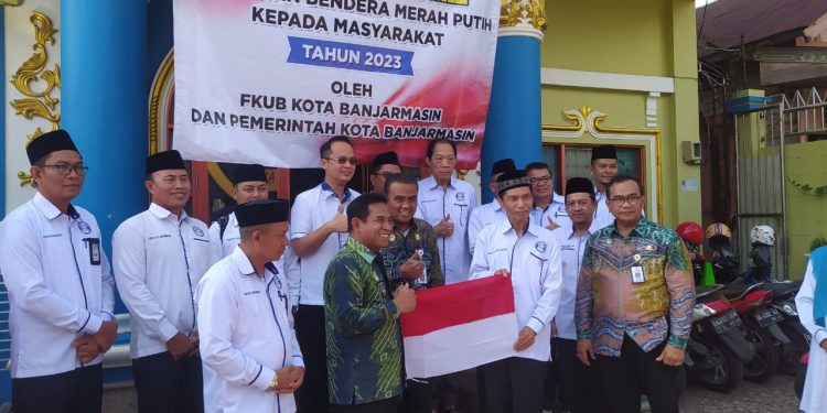 Penyerahan Bendera Merah Putih kepada perwakilan warga. (foto : shn/seputaran)