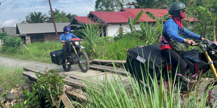 Tim Pusling Palnam Dispersip Kalsel gunakan trail menuju SDN Pembantanan 1 yang tidak bisa diakses dengan roda empat. (foto : istimewa)