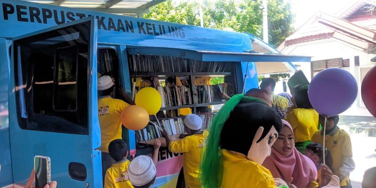 Mobil Pusling Dispersip Kalsel yang ada di lokasi kegiatan saat diserbu anak-anak. (foto : istimewa)