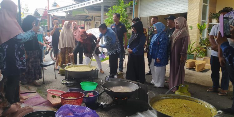 Walikota Banjarmasin H Ibnu Sina saat mengawah bubur asyura bersama warga Sungai Andai. (foto : shn/seputaran)