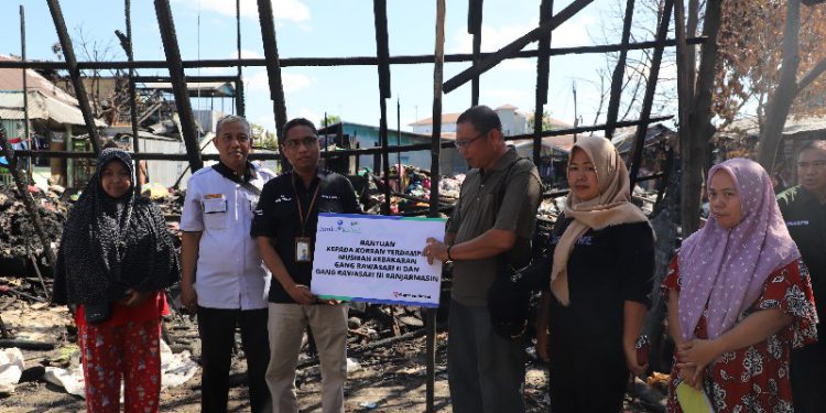 Sekretaris UPZ Bank Kalsel Junaidi menyerahkan bantuan kepada korban kebakaran di Jalan Rawasari Banjarmasin. (foto : istimewa)