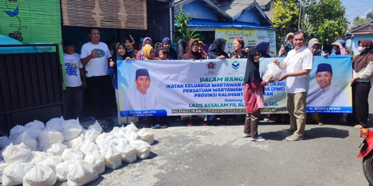 Ketua PWI Kalsel Zainal Helmie saat membagikan paket sembako kepada warga kurang mampu. (foto : istimewa)