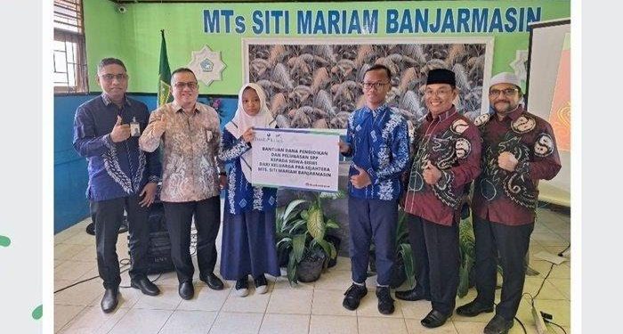 Penyerahan bantuan secara simbolis oleh Direktur UPZ Bank Kalsel, H M Fajri Muhtadi kepada perwakilan siswa/siswi Mts Siti Mariam Banjarmasin. (foto : istimewa)