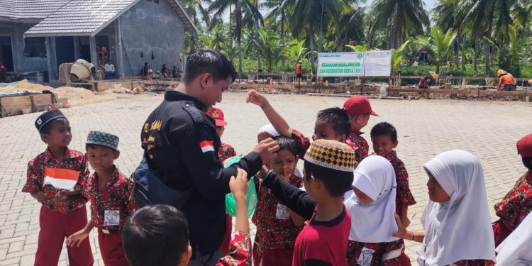 Petugas MPK Dispersip Kalsel saat membagikan bendera Merah Putih kepada para pelajar. (foto : istimewa)