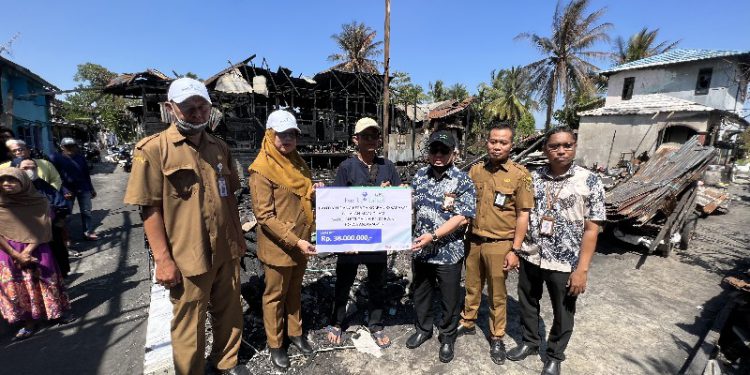 Bantuan secara langsung diserahkan oleh Direktur UPZ Bank Kalsel M Fajri Muhtadi kepada Achmadi selaku perwakilan warga yang terdampak kebakaran. (foto : istimewa/Bank Kalsel)