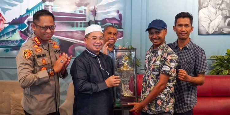 Ketua FWB Banjarmasin menyerahkan piala bergilir kejuaraan bulu tangkis antar desk wartawan kepada walikota Banjarmasin H Ibnu Sina. (foto : shn/seputaran)