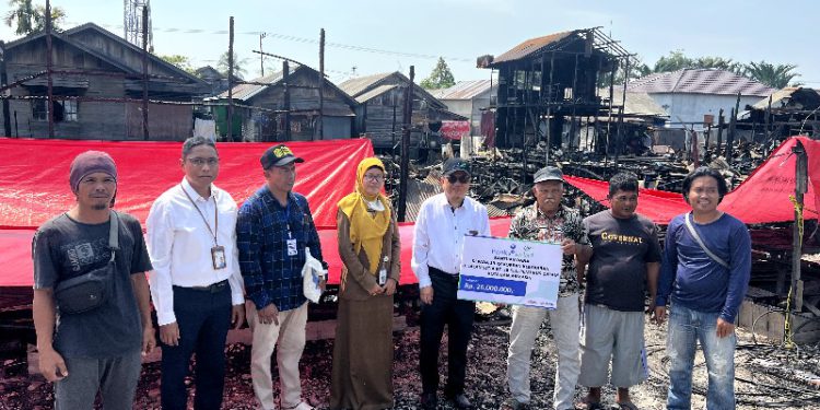 Bantuan secara langsung diserahkan oleh Direktur UPZ Bank Kalsel, M. Fajri Muhtadi kepada Sarbani selaku perwakilan warga. (foto : istimewa/Bank Kalsel)