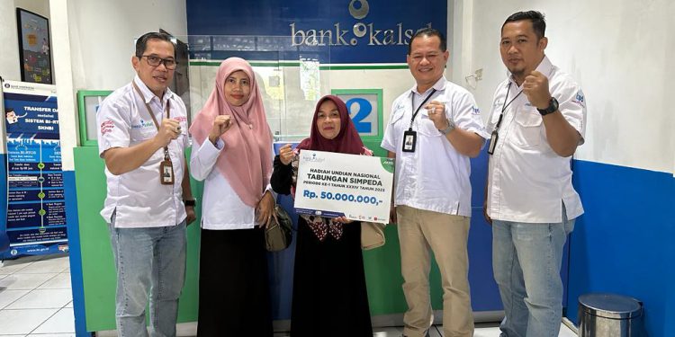 Penyerahan hadiah secara 
simbolis diserahkan oleh Kepala Divisi Dana & Digital Banking Bank Kalsel, Suriadi kepada Erlin 
Kencanawati.