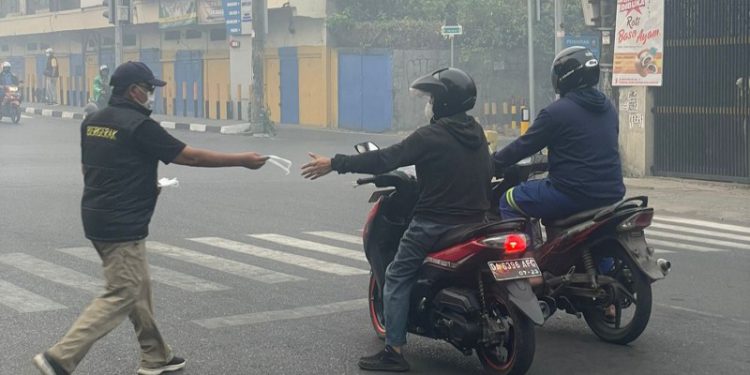 Gubernur Kalsel H Sahbirin Noor atau Paman Birin saat bagikan masker ke pengguna jalan. (foto : istimewa/Adpim Kalsel)