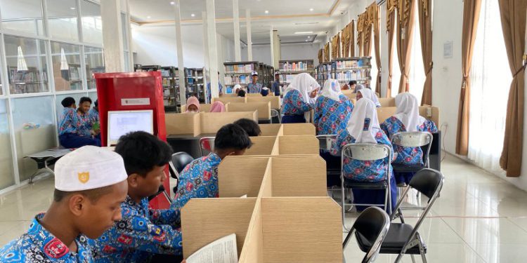 Para pelajar SMPN 10 Banjarmasin saat menikmati layanan atau koleksi buku Perpustakaan Piere Tendean Banjarmasin. (foto : sdy/smr)