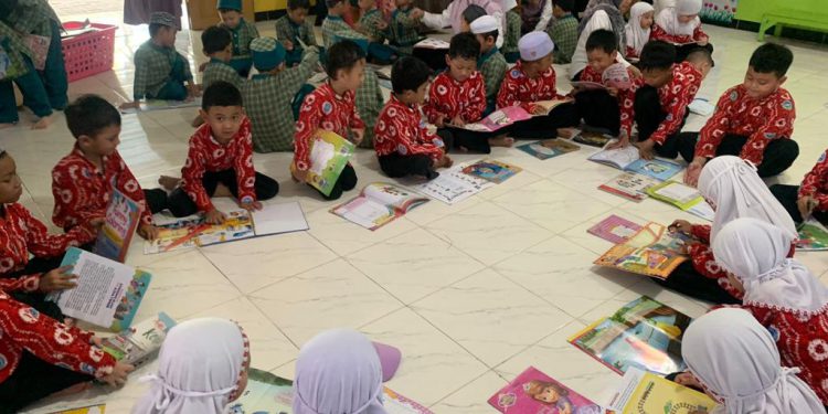 Anak-anak PAUD Tunas Mulia saat menikmati buka koleksi Pusling Dispersip Kalsel. (foto : istimewa)