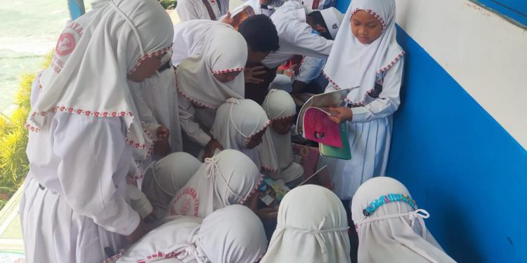 Para murid SDN Kelayan Timur 3 Banjarmasin terlihat antusias mencari buku bacaan dari motor trail Dispersip Kalsel. (foto : istimewa)