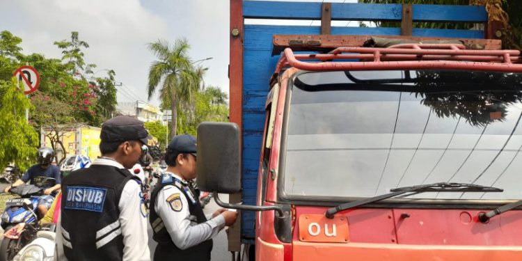 Petugas Dishub Banjarmasin saat meminta kelengkapan surat kepada salah satu pengemudi angkutan pada giat ODOL. (foto : shn/seputaran)