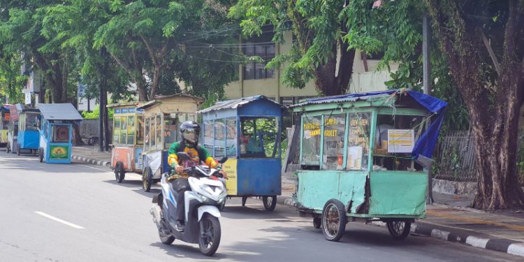 PKL Jalan Anang Adenansi saat mendorong rombong atau gerobak untuk berjualan. (foto : shn/seputaran)