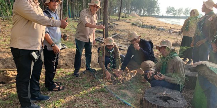 Penanaman pohon Cemara Laut oleh Ketua PWM Kalsel diikuti peserta kemah penghijauan. (foto : istimewa)