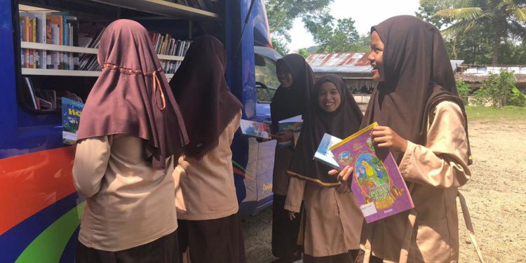 Para pelajar tampak antusias mencari buku bacaan di Mobil Pusling Dispersip Kalsel. (foto : istimewa)