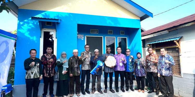 Pihak Bank Kalsel foto bersama dengan penerima bantuan program bedah rumah. (foto : istimewa)