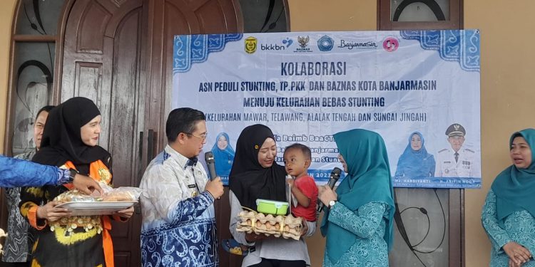 Walikota Banjarmasin H Ibnu Sina didampingi Ketua TP PKK Banjarmasin Siti Wasilah Ibnu Sina saat memberikan paket makanan tambahan kepada warga. (foto : shn/seputaran)