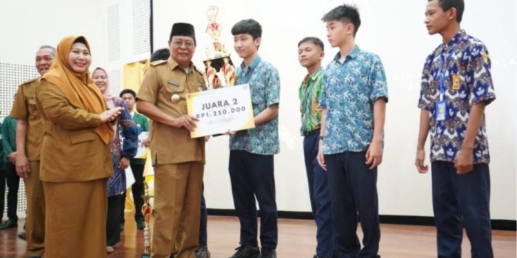 Gubernur Kalsel H Sahbirin Noor ditemani istri Hj Raudatul Jannah menyerahkan piala kepada pemenang lomba Banua Mathematics Olympiad 2024 SMA Banua Kalsel. (foto : adpim Kalsel)