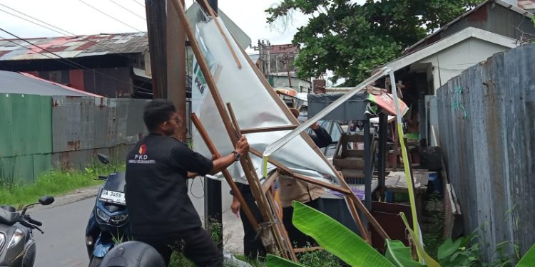 Tim penertiban APK saat melepaskan salah satu baliho Caleg yang masih terpasang. (foto : shn/seputaran)