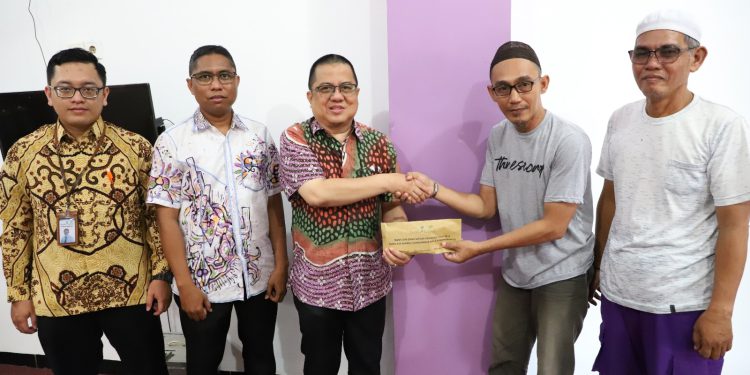 Penyerahan bantuan kepada pihak panitia Haul Guru Zuhdi.(FOTO:IST)