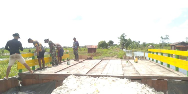 Personel TMMD ke-119 saat melakukan pengecetan jembatan. (foto : shn/seputaran)