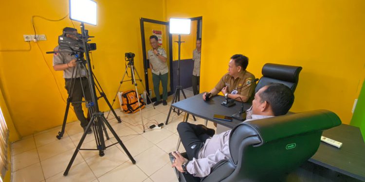 Kepala BPBD Kalsel Raden Suria Fadliansyah sedang melakukan uji coba alat media podcast, di Ruang KIE Kantor BPBD Kalsel. (foto : istimewa)