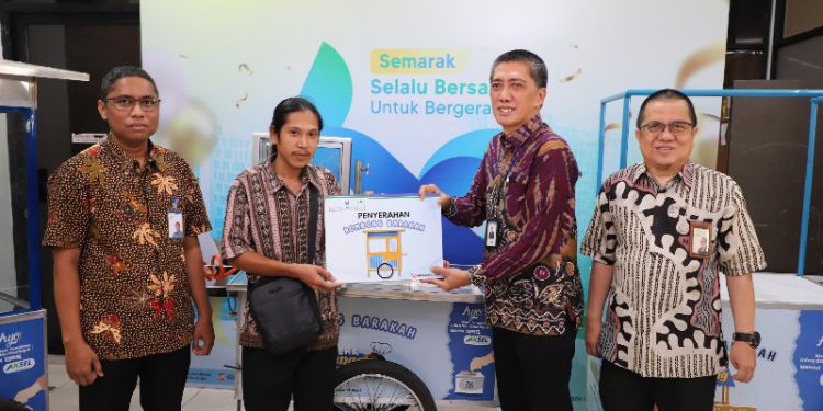 Penyerahan bantuan gerobak secara simbolis oleh Direktur Utama Bank Kalsel Fachrudin kepada pelaku UMKM di Banjarmasin. (foto : istimewa)