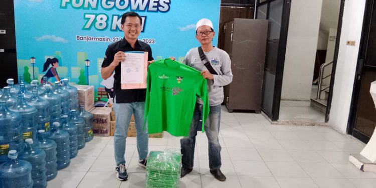 Bantuan baju seragam diserahkan bagian Humas dari Divisi Sekretaris Perusahaan Bank Kalsel, Syarif kepada Sekretaris Relawan AKT-05, Ady Wiryawan. (foto : istimewa)