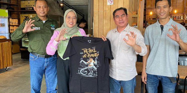 Ketua PWI Kalsel Zainal Helmie menerima cindera mata berupa baju kaos hitam bertuliskan Geopark Meratus dari Kepala DLH Kalsel Hanifah. (foto : istimewa)