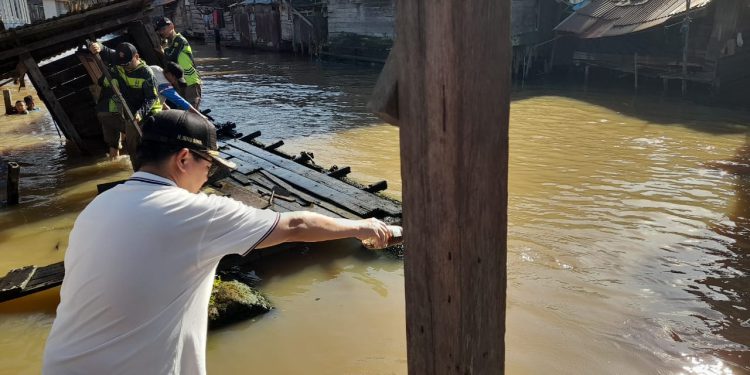 Walikota Banjarmasin H Ibnu Sina saat ikut pembongkaran jamban. (foto : shn/seputaran)