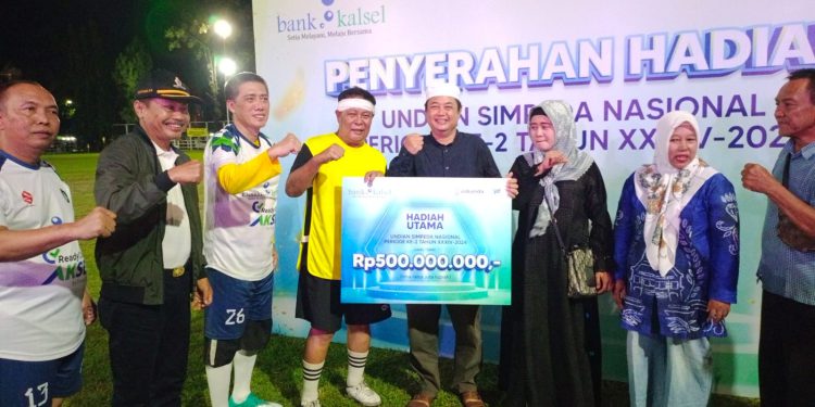 Gubernur Kalsel H Sahbirin Noor atau Paman Birin secara simbolis menyerahkan hadiah utama undian Simpeda Nasional kepada nasabah Bank Kalsel Effendi. (foto : istimewa)