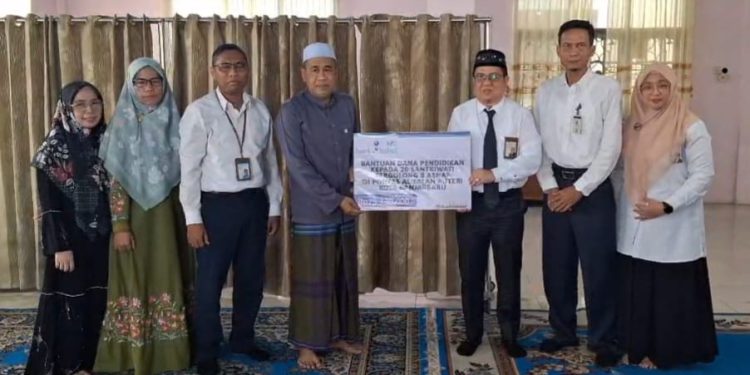 Penyerahan bantuan secara simbolis diserahkan oleh Direktur UPZ Bank Kalsel M Fajri Muhtadi kepada Pimpinan Pondok Pesantren Al Falah Puteri Kota Banjarbaru KH Mukhlis Kaspul Anwar. (foto : Bank Kalsel)