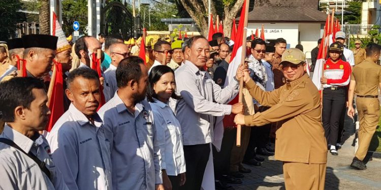 Walikota Banjarmasin H Ibnu Sina membagikan bendera merah putih saat apel. (foto : shn/seputaran)