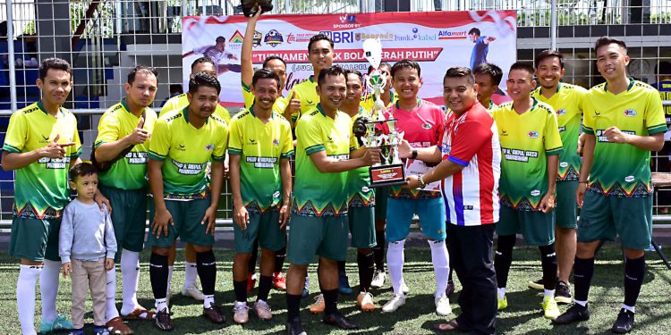 Ketua Panitia Rudi Setiawan alias Edoy saat menyerahkan trophy juara pertama untuk Tim RSUD Abdul Aziz Marabahan FC. (foto : istimewa)