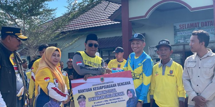 Gubernur Kalsel H Sahbirin Noor atau Paman Birin didampingi Ketua PKK Kalsel Hj Raudatul Jannah atau Acil Odah saat menyerahkan bantuan lumbung sosial. (foto : MC Kalsel)