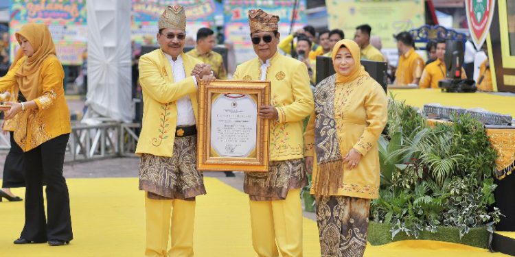 Ketua DPRD Kalsel, H Supian HK memberikan piagam penghargaan kepada Gubernur Kalsel H Sahbirin Noor dan Ketua TP PKK Kalsel Hj Raudatul Jannah pada Harjad ke-74 Kalsel. (foto : istimewa)