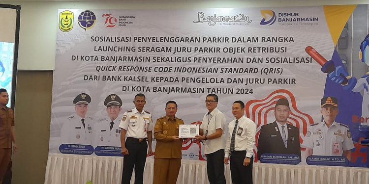 Direktur Utama Bank Kalsel Fachrudin saat menyerahkan secara simbolis QRIS Bank Kalsel untuk pengelola parkir yang diwakili Walikota Banjarmasin H Ibnu Sina. (foto : shn/seputaran)