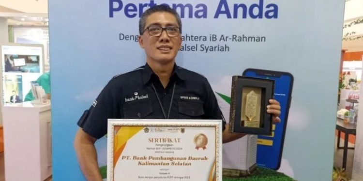 Dirut Bank Kalsel Fachrudin saat menunjukkan piagam penghargaan yang diterima. (foto : istimewa)