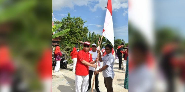 Sekdakot Banjarmasin Ikhsan Budiman saat membagikan bendera Merah Putih kepada warga. (foto : shn/seputaran)