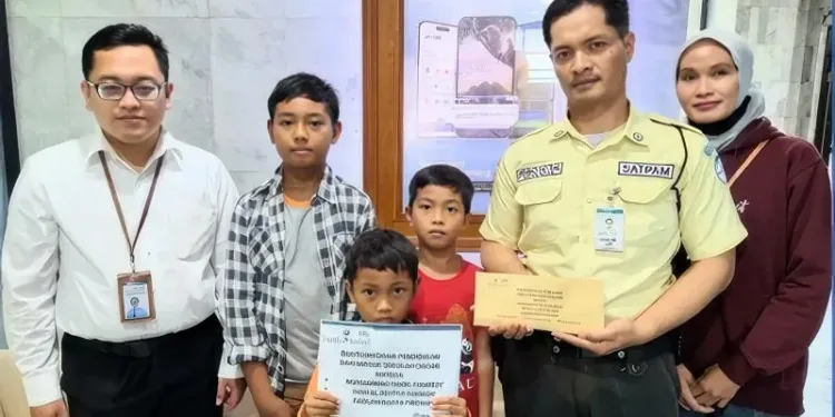 Bantuan secara simbolis diserahkan oleh Staf UPZ Bank Kalsel Aldi kepada tiga putra M. Fendy Irma. (foto : istimewa)