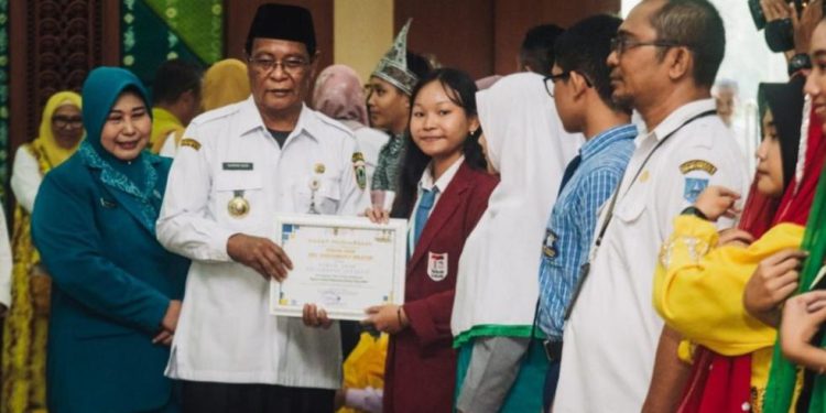 Gubernur Kalsel H Sahbirin Noor atau Paman Birin bersama istri Hj Raudatul Jannah atau Acil Odah saat memberikan piagam penghargaan pada peringatan HAN. (foto : adpim Kalsel)