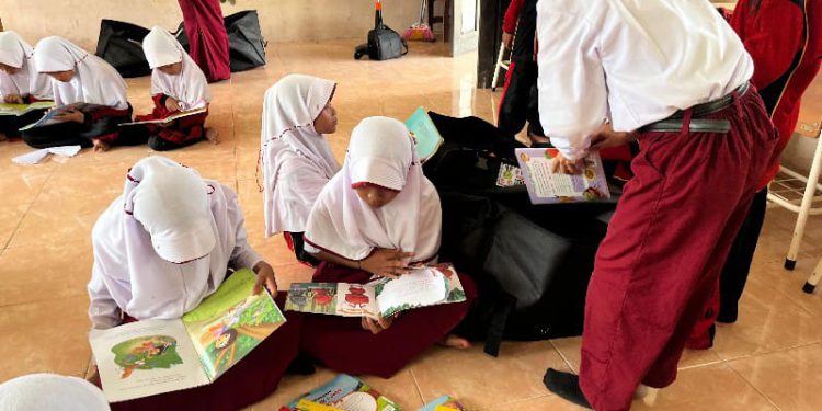 Siswa SDN Basirih 10 Banjarmasin saat antusias membaca koleksi buku Pusling Dispersip Kalsel. (foto : istimewa)