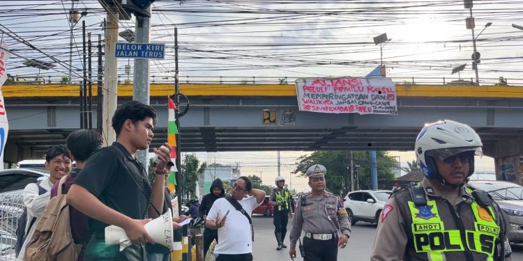 Aksi pembentangan spanduk dan selebaran Aliansi Pemuda Peduli Pemilu di Flyover A Yani. (foto : sdy/seputaran)