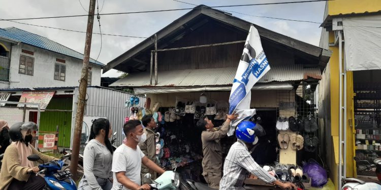 Personel Satpol PP bersama Bawaslu Banjarmasin saat membersihkan APK Paslon Walikota dan Wakil Walikota Banjarmasin. (foto : shn/seputaran)