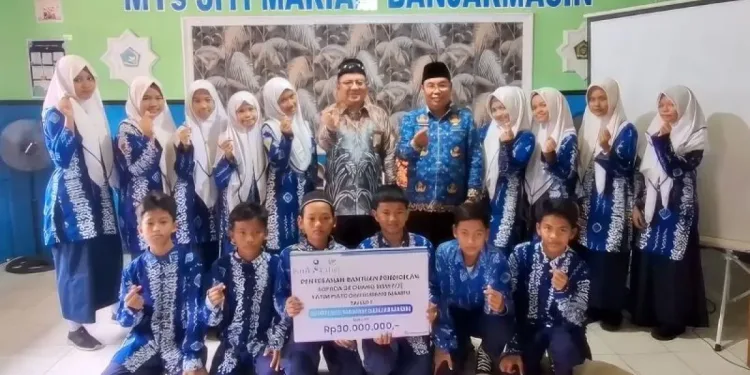 Penyerahan bantuan Bank Kalsel kepada 24 pelajar MTs Siti Mariam. (foto : istimewa)