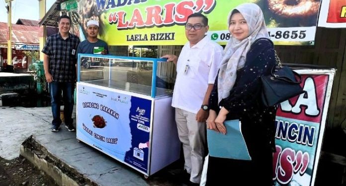 Penyerahan rombong barakah olehg perwakilan  Kantor Cabang Syariah Kandangan kepada dua mustahik. (foto : istimewa)