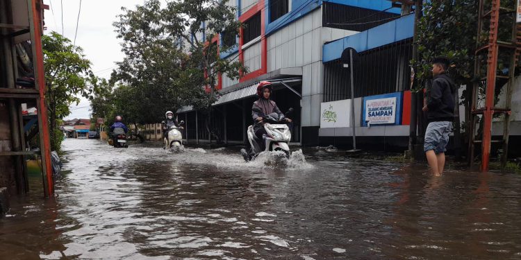 Pengendara saat melintas di jalan yang tergenang banjir. (foto : shn/seputaran)