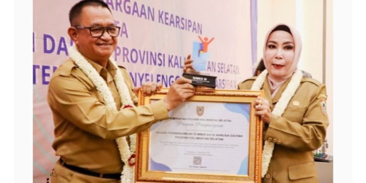 Kepala Dispersip Kalsel Hj Nurliani Dardie saat menyerahkan penghargaan. (foto : istimewa)